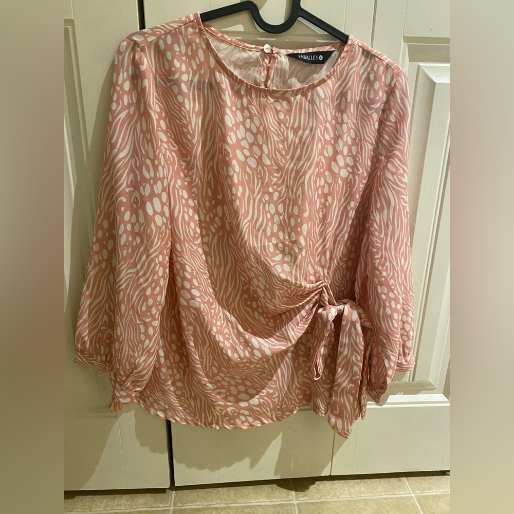 Baby pink blouse with white swirls on it